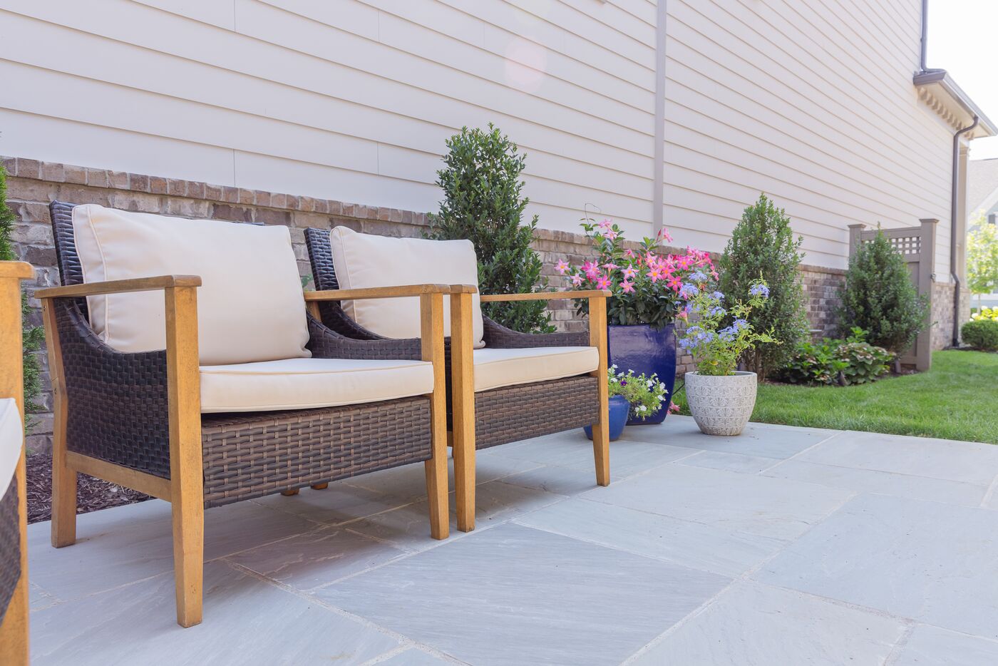 Flagstone patio with teak seating and blue glazed container plantings